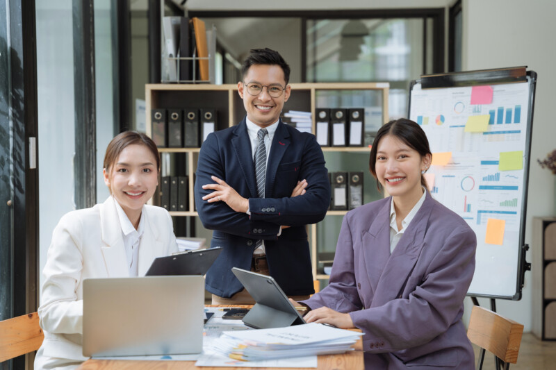 Smiling confident mature businessman team looking at camera in office.